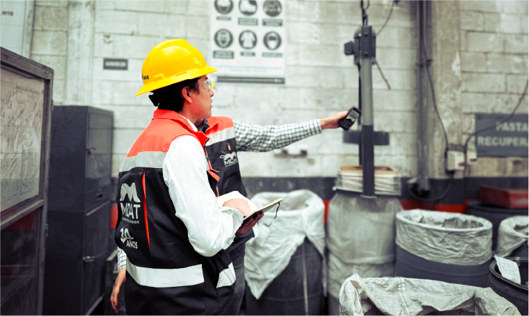 Técnico de MCAT con casco y chaleco realizando inspección de seguridad en planta industrial